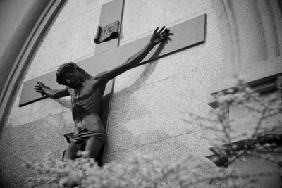 Low angle view of jesus christ statue with cross on wall