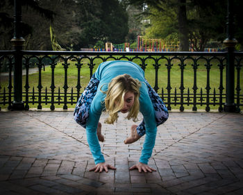 Young woman exercising in gazebo at park
