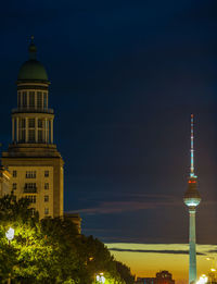 Illuminated buildings in city against sky at night