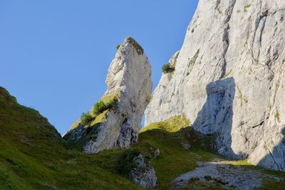 Low angle view of rocks against clear sky