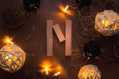 Directly above shot of letter n blocks and illuminated lights on wooden table