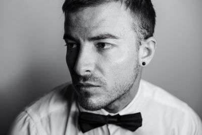 Close-up of young man looking away against wall