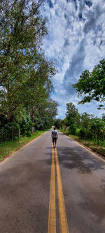 Rear view of man walking on road