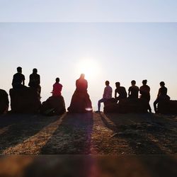 Group of people sitting against clear sky