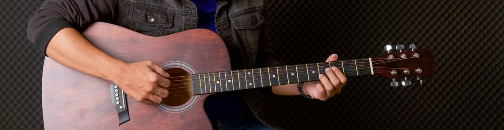 Midsection of person playing guitar