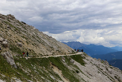 People on mountain against sky