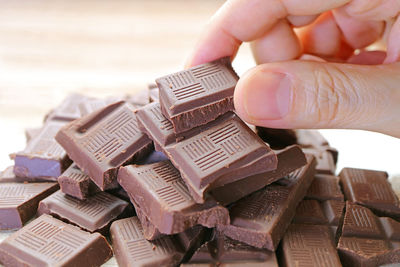 Closeup man's hand picking a chocolate chunk from the pile