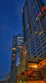 Low angle view of illuminated buildings against sky at night