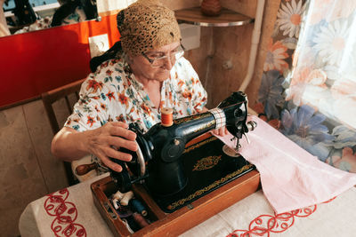 Midsection of woman holding umbrella on table