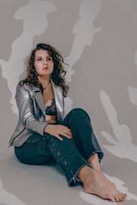 Portrait of young woman sitting on bed at home