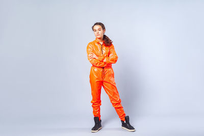 Portrait of young woman standing against white background