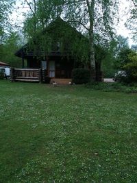 House on field against trees