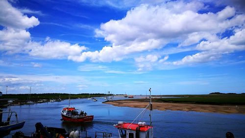 Boats moored on river against sky