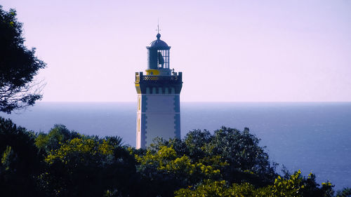         view of the beautiful cape spartel lighthouse that appears behind the trees  