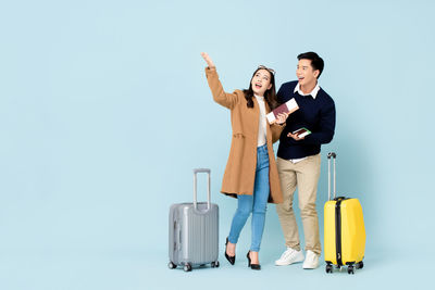 Young couple standing against gray background