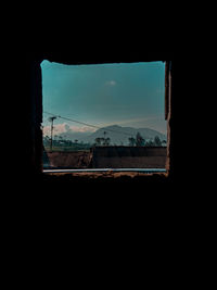 Silhouette buildings seen through window