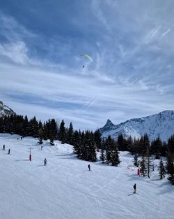 People on skiing on snowcapped mountain against sky