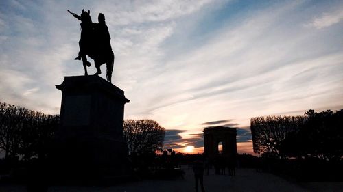 Low angle view of silhouette statue against sky