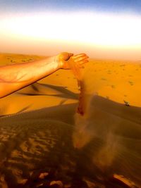 Scenic view of sand dunes against sky at sunset