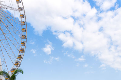 Low angle view of ferris wheel against blue sky