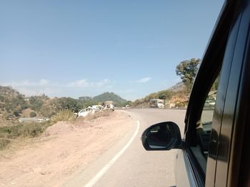 View of vehicles on road along trees