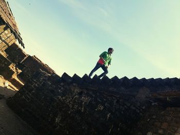 Low angle view of boy against sky