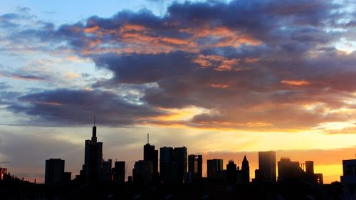 Silhouette buildings against sky during sunset