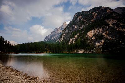 Scenic view of lake by mountains against sky