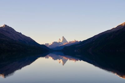 Scenic view of lake by mountains against sky during sunset