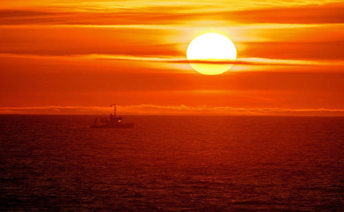 Scenic view of sea against orange sky