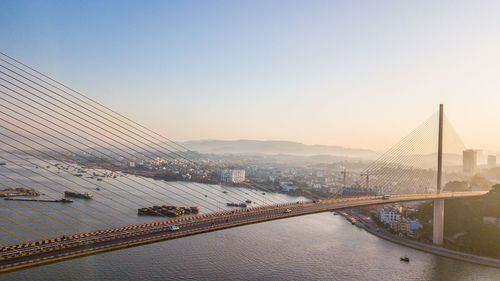 View of suspension bridge against sky in city