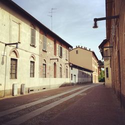 Road amidst buildings against sky