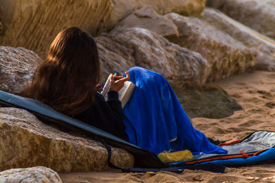 Rear view of woman sitting on deck chair