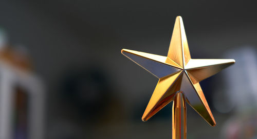 Close-up of star christmas hanging against blurred background
