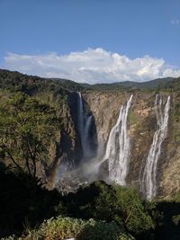 Scenic view of waterfall against sky