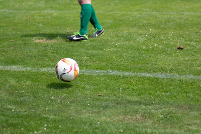 Low section of person with ball on field