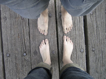 Low section of man standing on wood