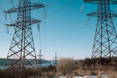 Low angle view of electricity pylon against sky