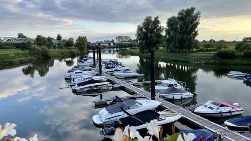 Panoramic view of sailboats moored in lake against sky