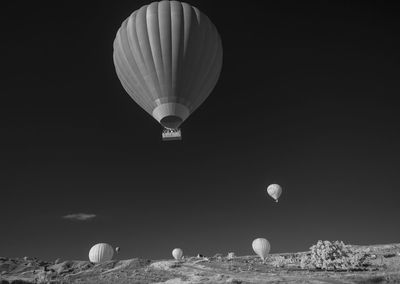 Hot air balloon flying over rocky mountain against sky