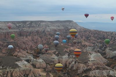 Hot air balloons over rocky landscape