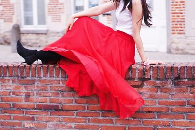 Woman sitting on retaining wall