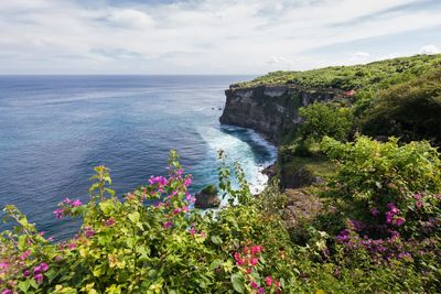 Scenic view of sea by cliff against sky