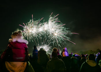 People watching firework display at night