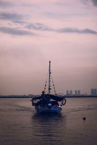 Ship in sea against sky during sunset