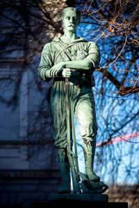 Low angle view of statue against bare trees