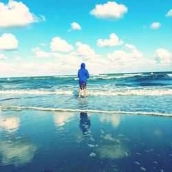 Rear view of man walking on beach