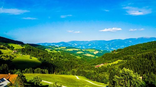 Scenic view of landscape and mountains against blue sky