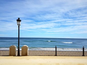 Street light on beach against sky