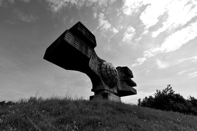 Low angle view of statue on field against sky